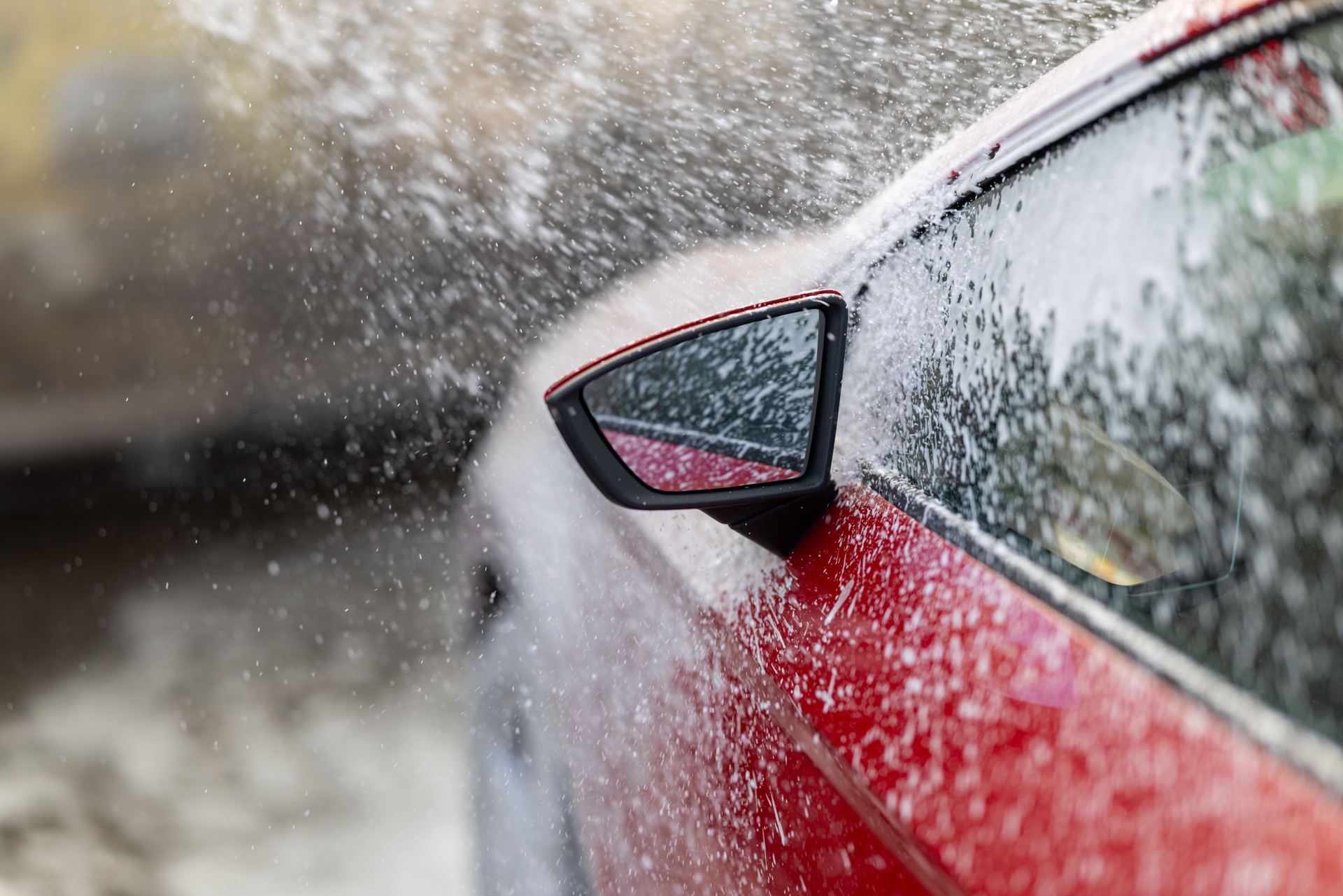 Red Car Undergoing a Refreshing Automated Car Wash